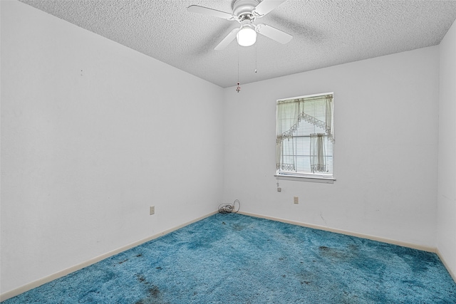 carpeted spare room with a textured ceiling and ceiling fan