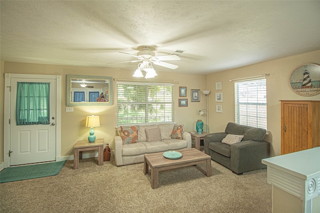 living room featuring light carpet, ceiling fan, and a textured ceiling