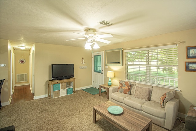 living room featuring ceiling fan, a textured ceiling, and carpet