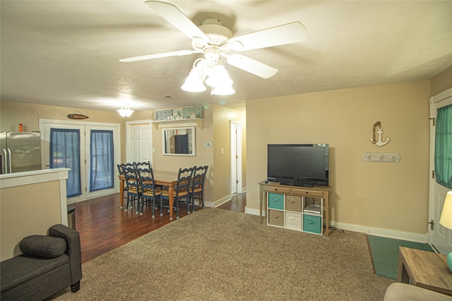 living room with ceiling fan and dark wood-type flooring