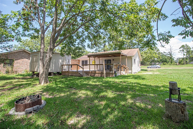 view of yard with a deck and an outdoor fire pit