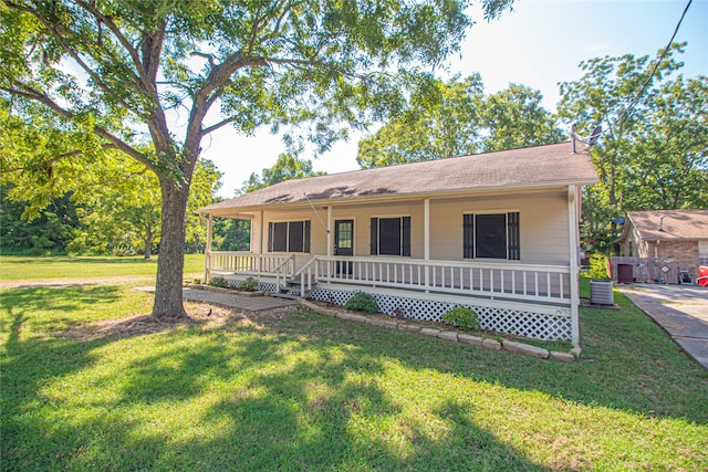 ranch-style home featuring a porch, a front yard, and central AC unit