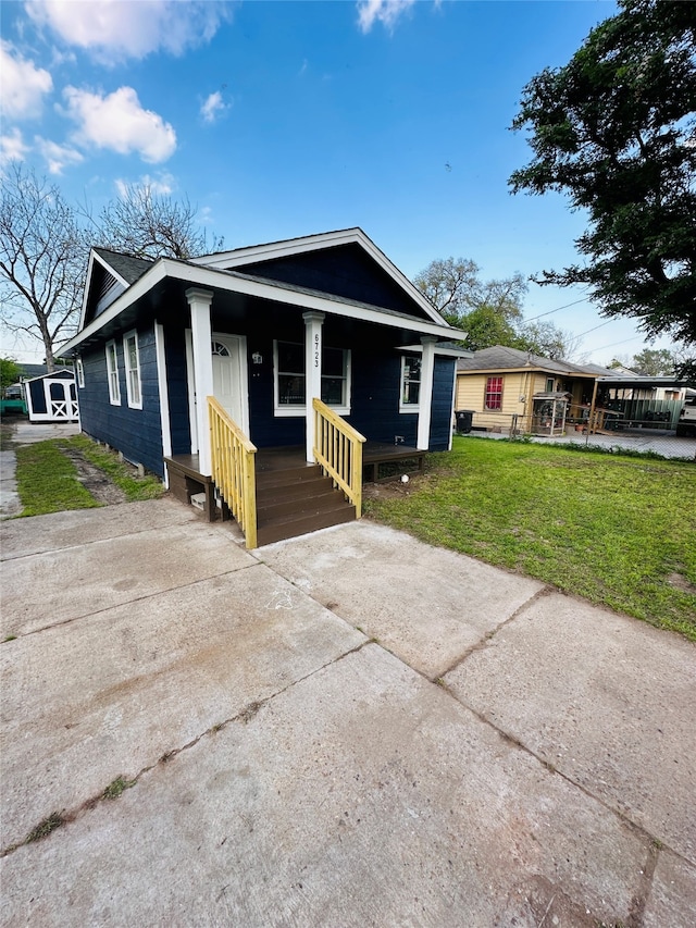 bungalow with covered porch and a front yard