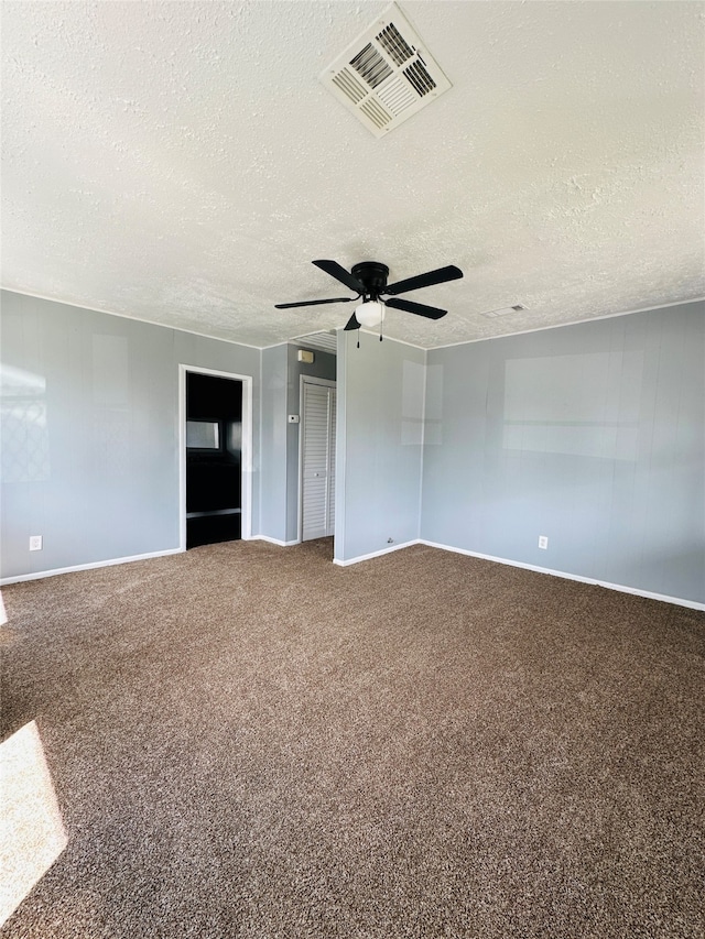 carpeted empty room featuring ceiling fan and a textured ceiling