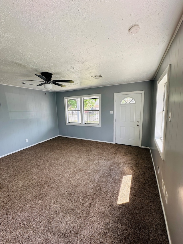 interior space with ceiling fan and a textured ceiling