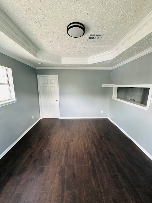 empty room with a tray ceiling, crown molding, and dark hardwood / wood-style flooring