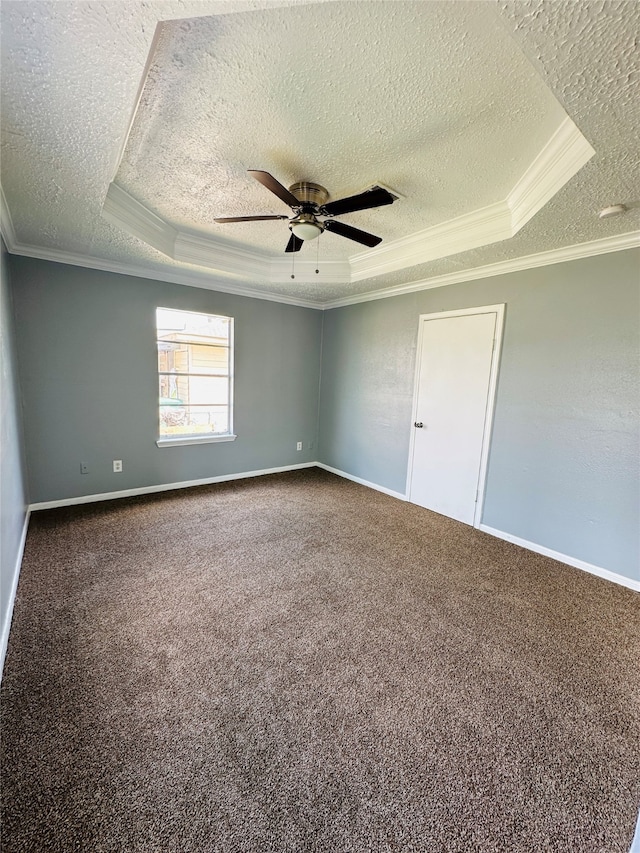 carpeted spare room featuring ceiling fan, a textured ceiling, ornamental molding, and a raised ceiling