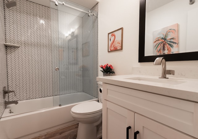 full bathroom with wood-type flooring, toilet, combined bath / shower with glass door, and vanity