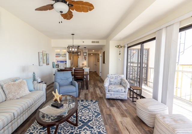 living room with dark hardwood / wood-style floors and ceiling fan with notable chandelier