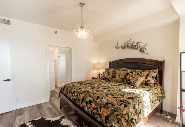 bedroom featuring wood-type flooring and an inviting chandelier