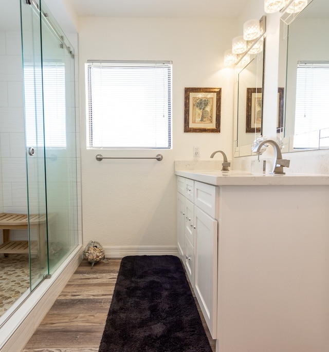 bathroom with hardwood / wood-style floors, a shower with shower door, and oversized vanity