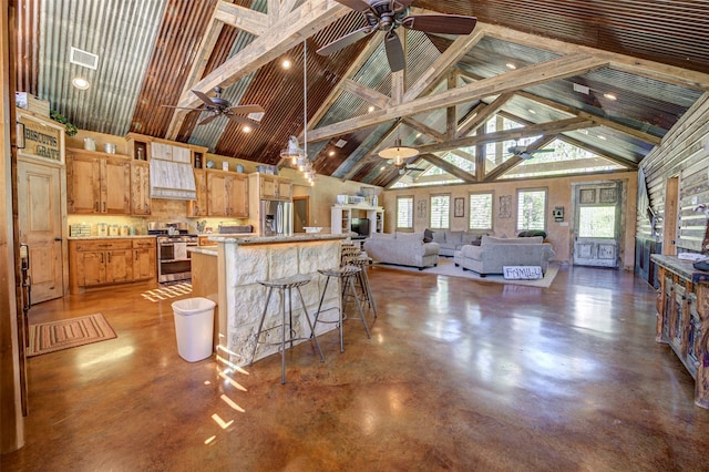 kitchen featuring stainless steel appliances, decorative light fixtures, high vaulted ceiling, ceiling fan, and a breakfast bar area