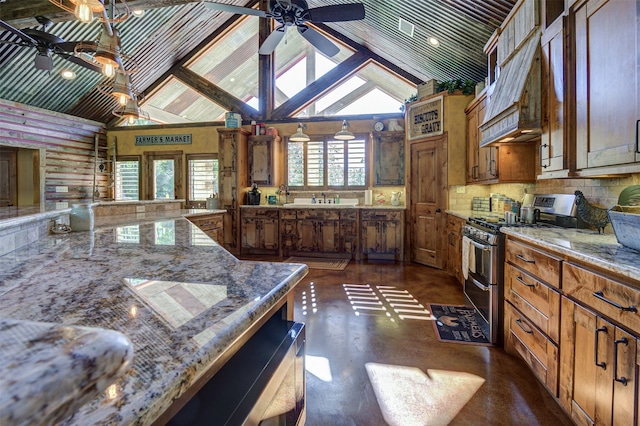 kitchen with ceiling fan, vaulted ceiling, stainless steel gas stove, and light stone counters