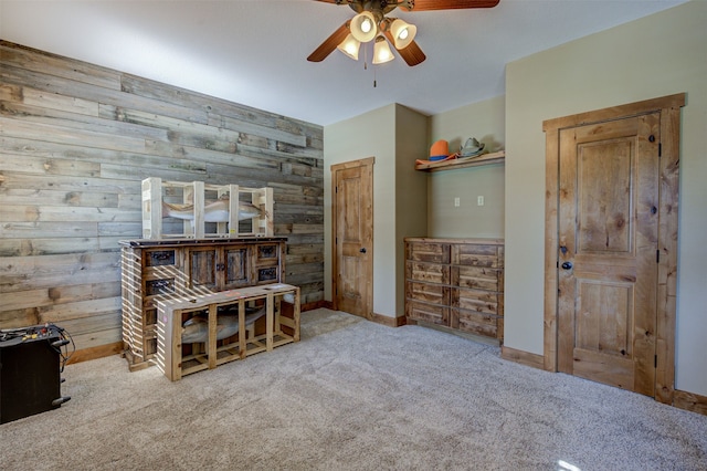 carpeted bedroom with wood walls and ceiling fan