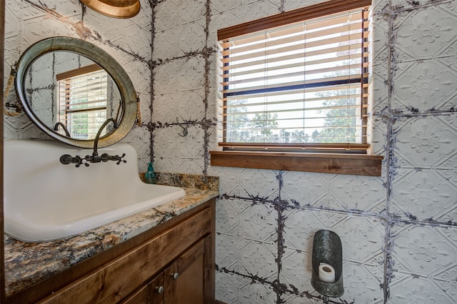 bathroom featuring vanity and tile walls