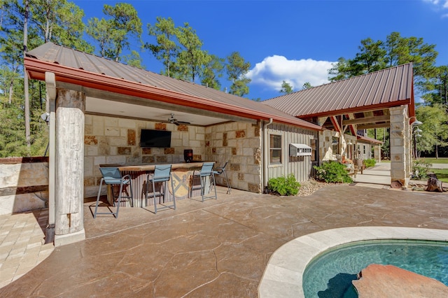 view of pool with a bar, ceiling fan, and a patio