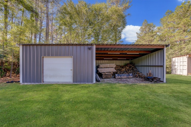 view of outdoor structure with a carport, a yard, and a garage