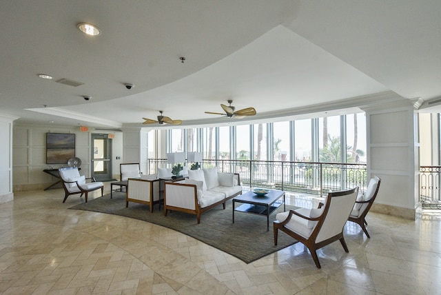 living room with ceiling fan, crown molding, a raised ceiling, and a wealth of natural light