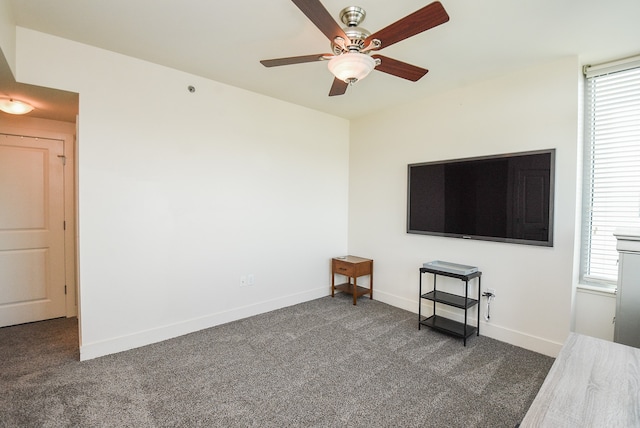 unfurnished living room with dark colored carpet and ceiling fan