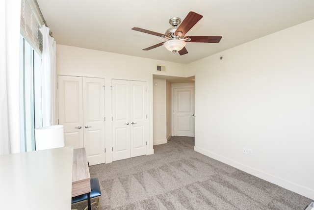 unfurnished bedroom featuring ceiling fan and light colored carpet