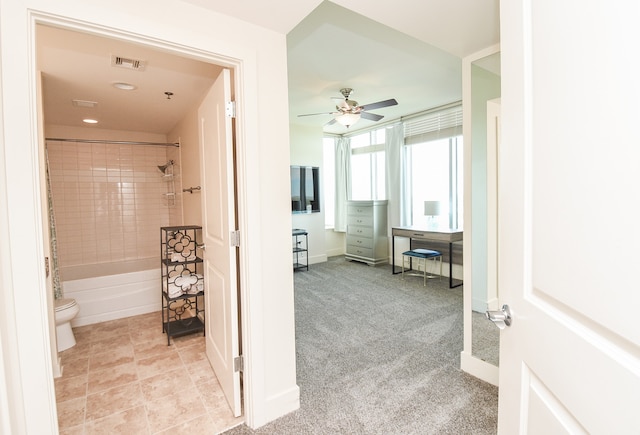 bathroom featuring tile flooring, ceiling fan, toilet, and tiled shower / bath