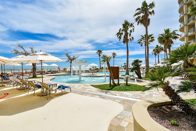 view of swimming pool with pool water feature and a patio