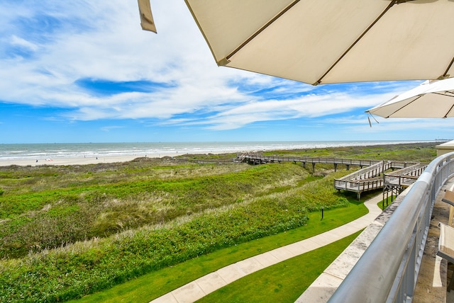 balcony with a water view and a view of the beach