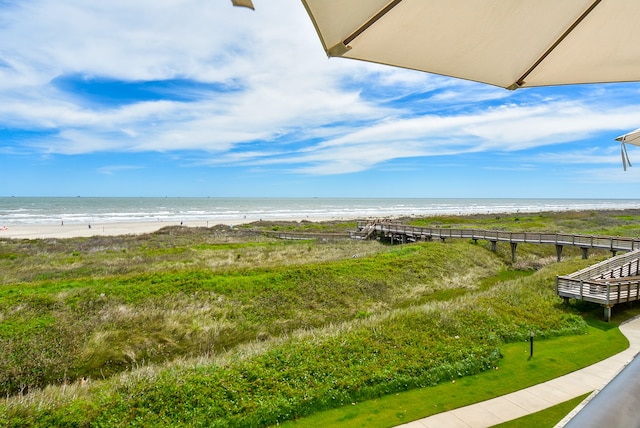 view of yard featuring a water view and a beach view