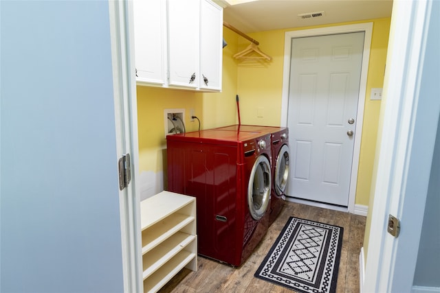 clothes washing area featuring cabinets, light hardwood / wood-style flooring, and separate washer and dryer