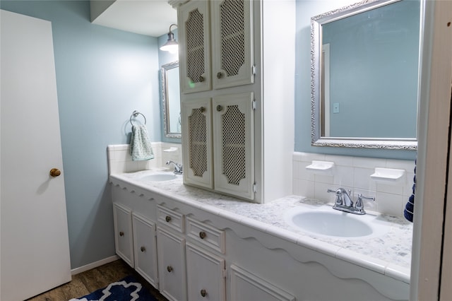 bathroom with backsplash, wood-type flooring, and dual bowl vanity