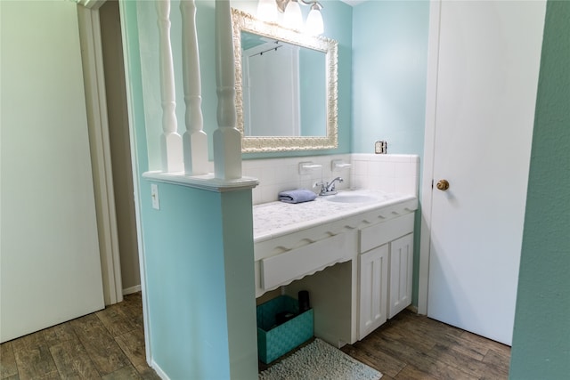 bathroom with tasteful backsplash, vanity, and hardwood / wood-style flooring