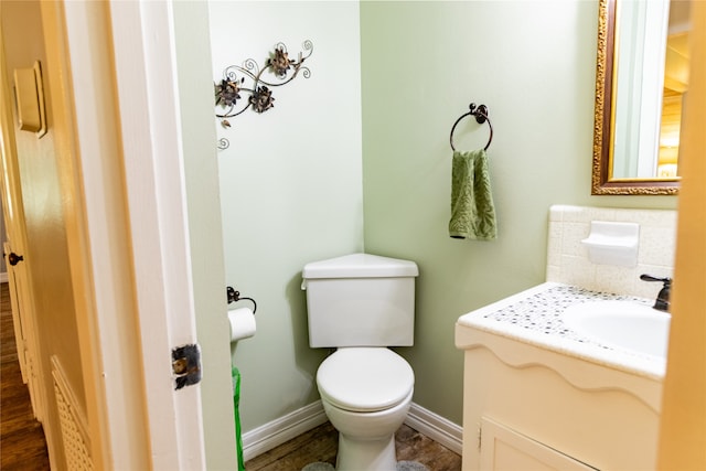 bathroom with hardwood / wood-style flooring, vanity, and toilet