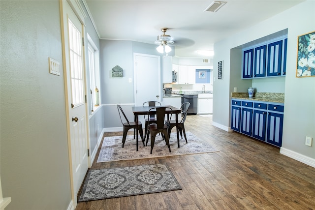 dining room with sink, dark wood-type flooring, and ceiling fan