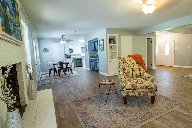 living area with ceiling fan, a fireplace, and hardwood / wood-style floors