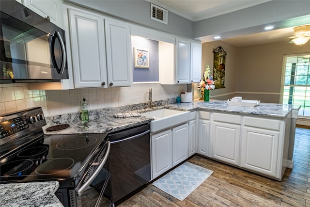 kitchen featuring kitchen peninsula, backsplash, stainless steel appliances, and white cabinetry