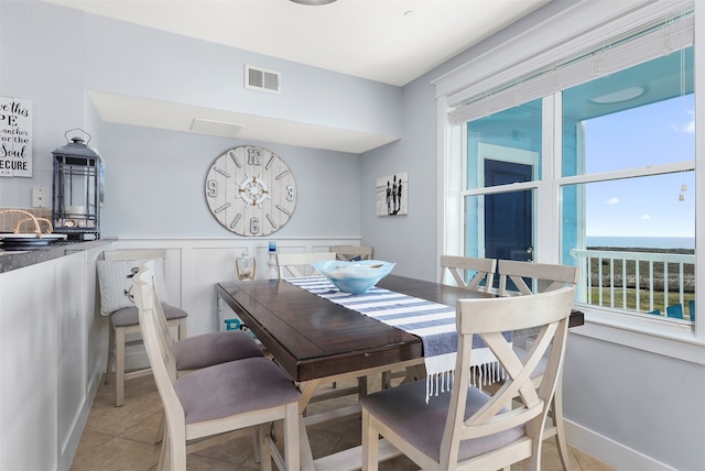 tiled dining space featuring a water view