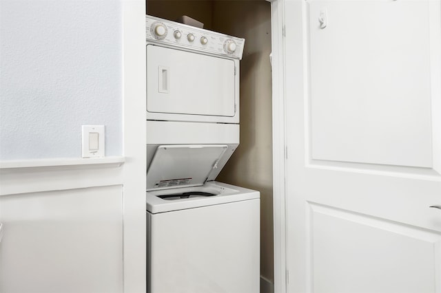 clothes washing area featuring stacked washer and dryer