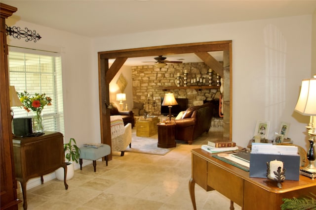 interior space featuring light tile floors, ceiling fan, and a fireplace