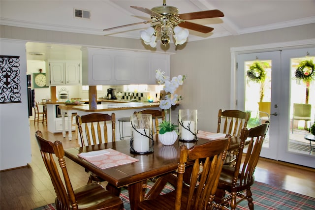 dining space featuring french doors, crown molding, ceiling fan, and hardwood / wood-style flooring