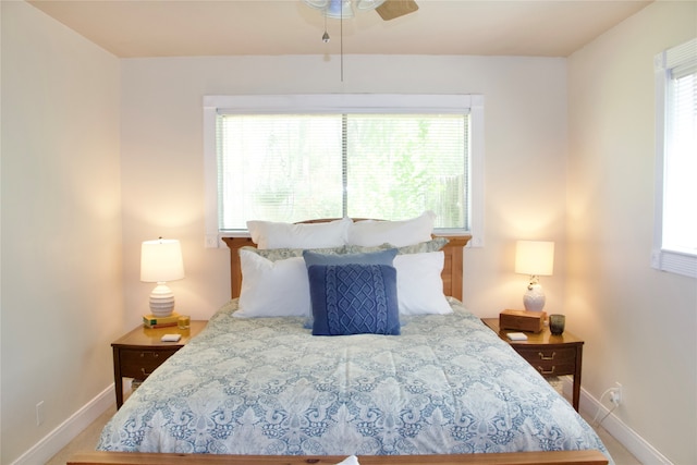 bedroom with ceiling fan, carpet flooring, and multiple windows