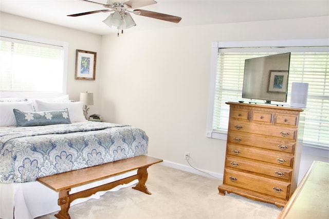 carpeted bedroom featuring ceiling fan and multiple windows