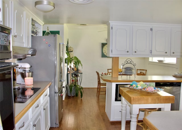 kitchen featuring dishwasher, black electric cooktop, white cabinetry, and light hardwood / wood-style flooring