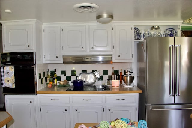 kitchen with white cabinets, tasteful backsplash, black appliances, and fume extractor