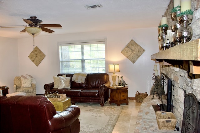 tiled living room featuring ceiling fan and a fireplace