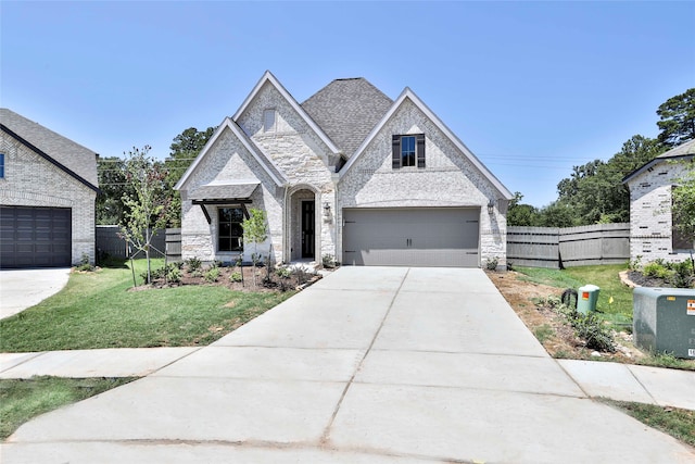 french country inspired facade with a front yard and a garage