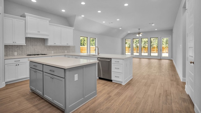 kitchen featuring light hardwood / wood-style floors, a kitchen island, ceiling fan, appliances with stainless steel finishes, and lofted ceiling