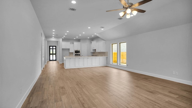 unfurnished living room with ceiling fan, a healthy amount of sunlight, and light wood-type flooring