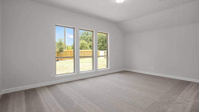 carpeted empty room featuring lofted ceiling