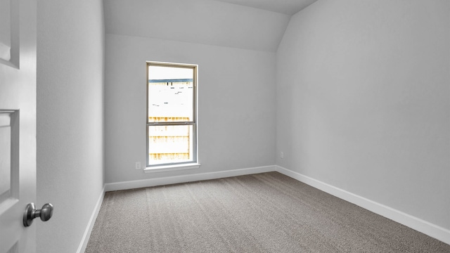 spare room with carpet, a healthy amount of sunlight, and vaulted ceiling