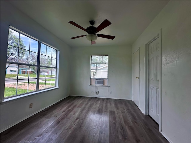 unfurnished bedroom featuring cooling unit, dark wood finished floors, a ceiling fan, and baseboards